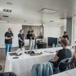 Team presenting ideas in a modern office with attentive audience and tech equipment.