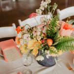 A sophisticated table setting with a vibrant floral centerpiece perfect for weddings or events.