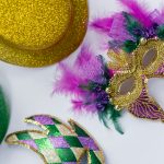 Colorful Mardi Gras mask and hats with glittery textures and feathers.