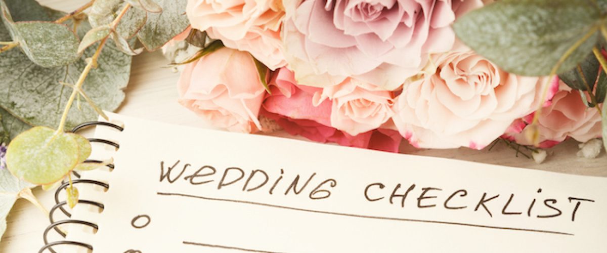 Wedding checklist with copy space and rose bouquet on the white desktop. Marriage planner concept, copy space.